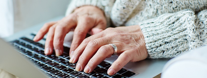 Hands of an older person using a laptop