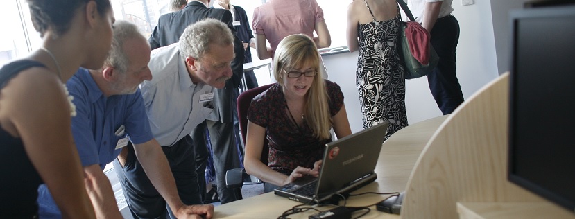 CRIS team of staff standing around a laptop