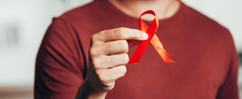 Man holding red AIDs awareness ribbon