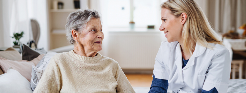 a sick senior woman sitting on bed at home. stock photo