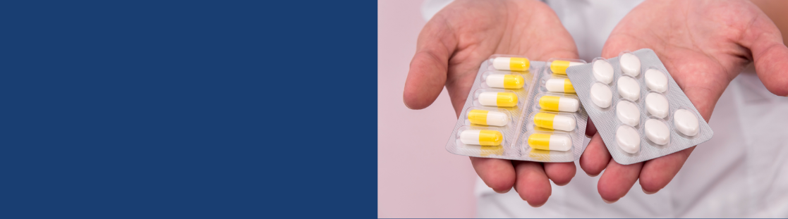 person holding out two different coloured packets of pills