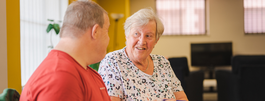 older woman speaking with man in community centre