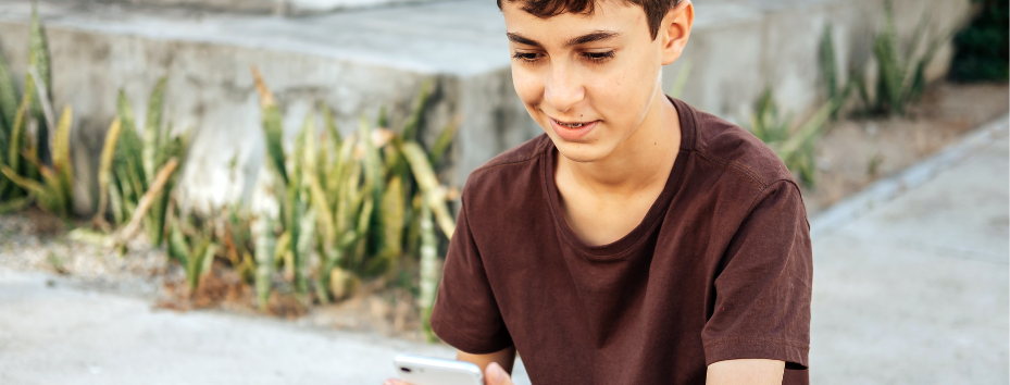 A teenage boy looking at a mobile phone