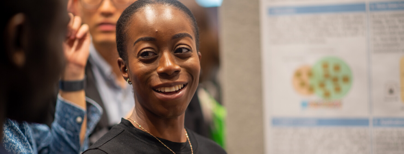 Clarissa Odoi in front of research poster