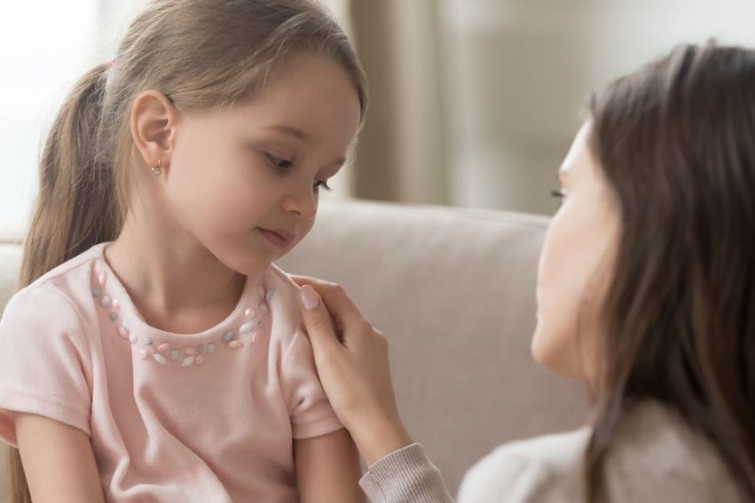 young girl with mother looking sad