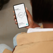 A person holds a smartphone displaying an agenda app with circular design elements