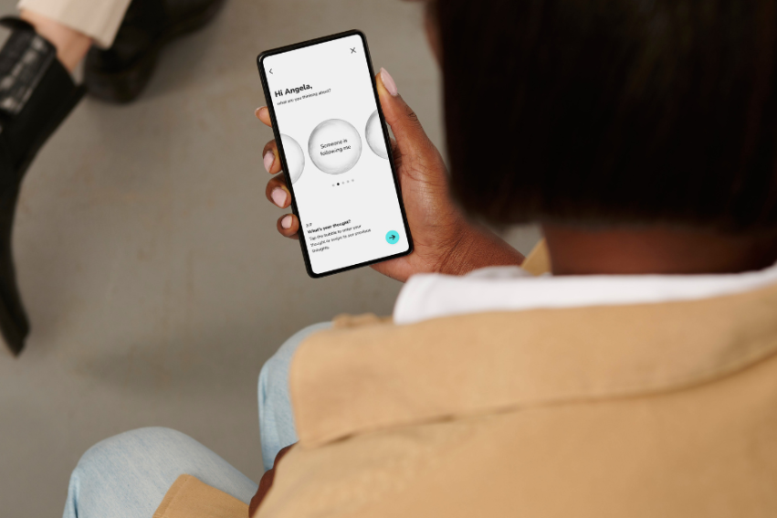 A person holds a smartphone displaying an agenda app with circular design elements