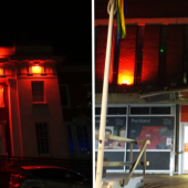 A building facade at night, dramatically illuminated in red light. Left: A classical structure with columns
