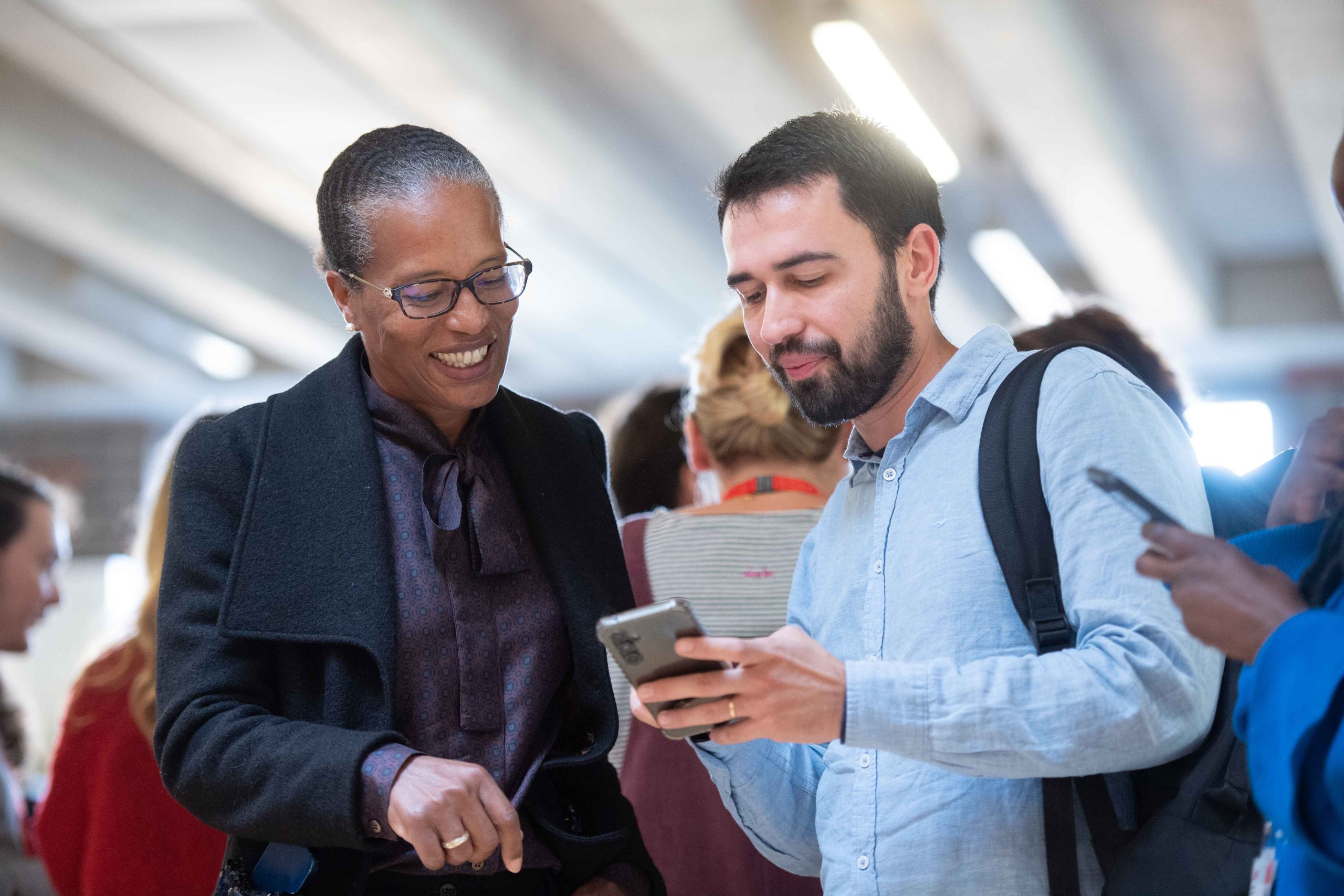 two people talking looking at a phone