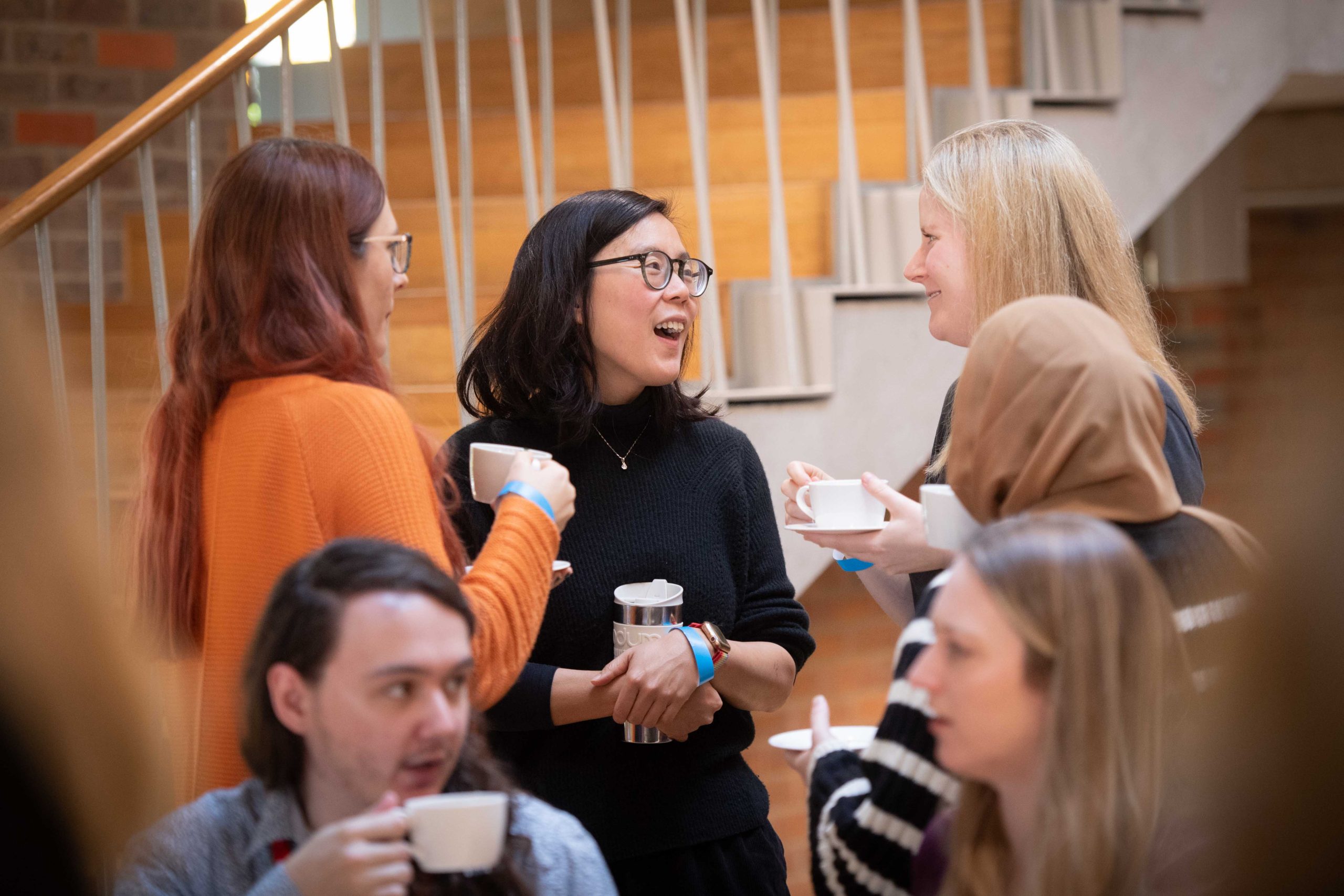 group of three women talking with coffee