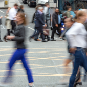 Blurry people walking across a road, conveying business