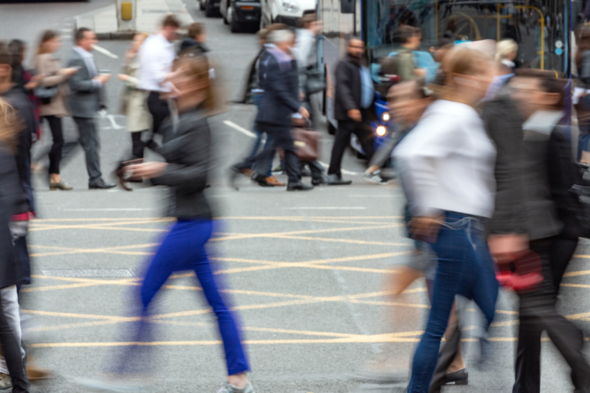 Blurry people walking across a road, conveying business
