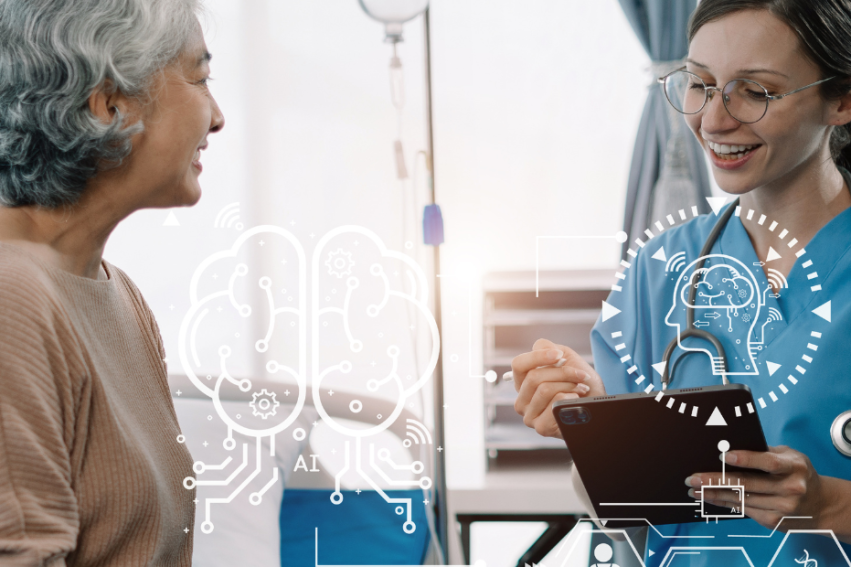 A female nurse in scrubs smiles while discussing with an older woman in a hospital setting