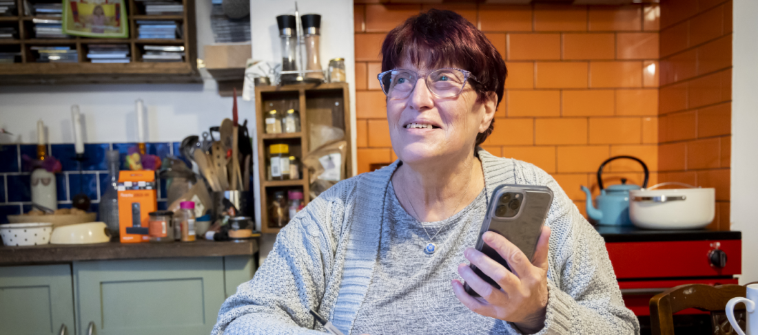 older woman holds phone - photo credit Old Age Image LIbrary
