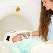 Woman operating an MRI machine with a patient lying down