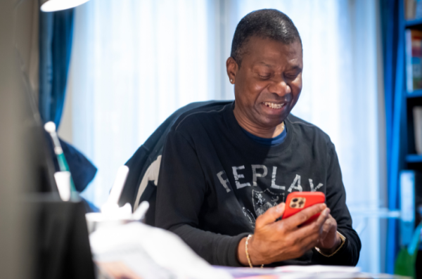 older black man using phone and smiling