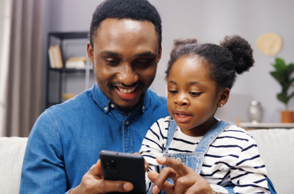 father and child looking at phone