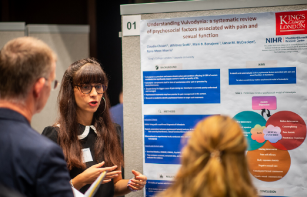 Student presenting their poster at conference