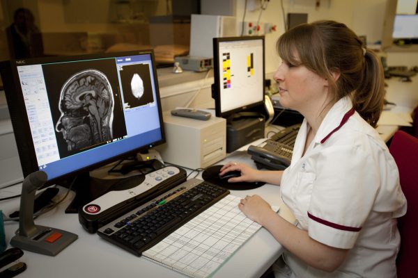 Female clinician looks at scan of bran