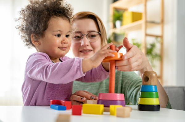 elixir baby plays with toy with mum