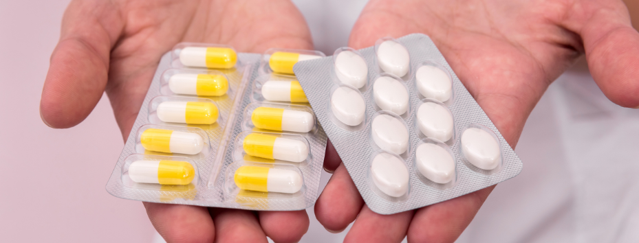 hands holding two different kinds of pill packets