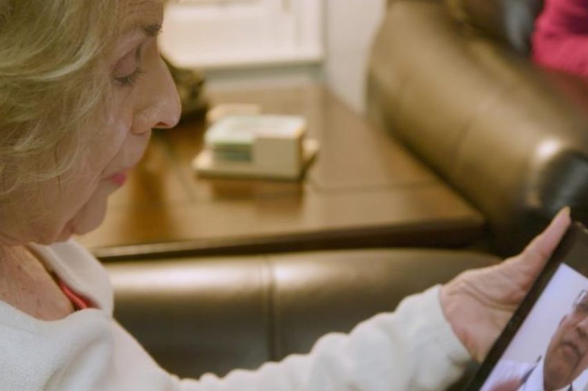 Woman looking at tablet with video playing