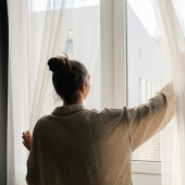 Women opens curtains at a window