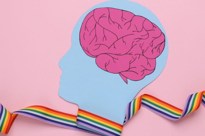 brain cut-out inside head, with rainbow ribbon across the image wrapped around the neck