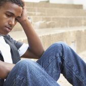 young man sitting on steps looking upset