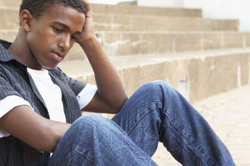 young man sitting on steps looking upset
